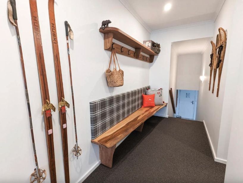 Entry hall with vintage skis, snowshoes and a tartan bench