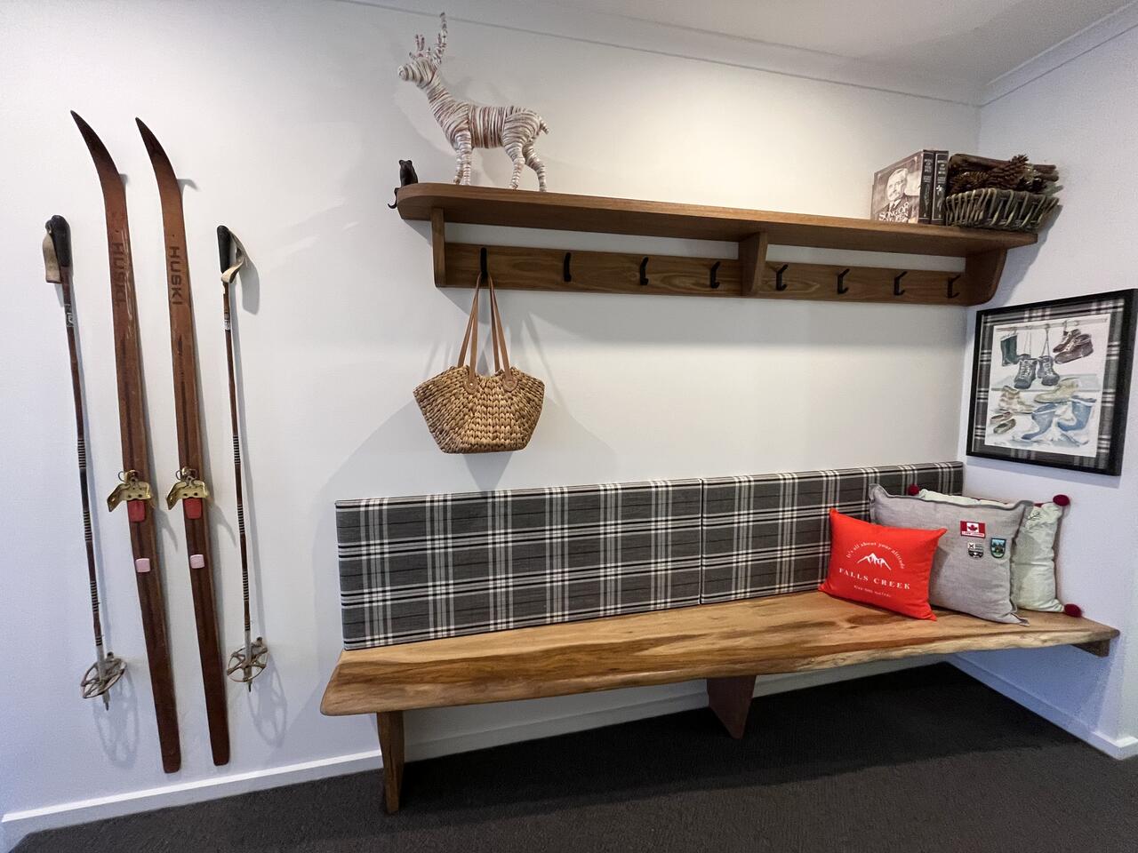 Entry with vintage skis, snowshoes and a timber bench