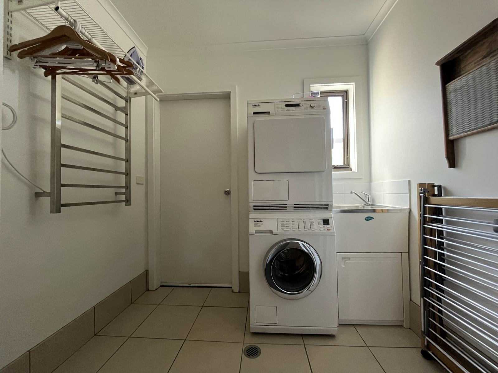Laundry with washer, dryer and heated drying rack